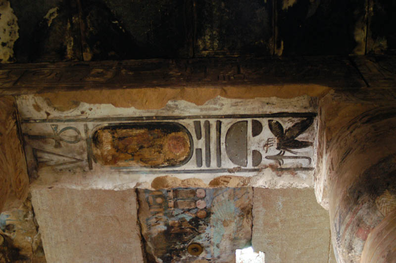 the scorched ceiling and defaced inscriptions in the columned hall