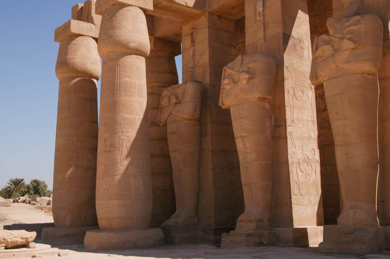 Columns and mummiform statues line the courtyard